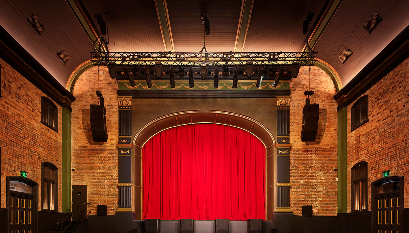 Image of The Princess Theatre interior with seating and red stage curtain.