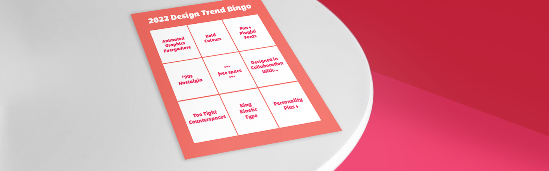 Design bingo card on white table against pink and red background