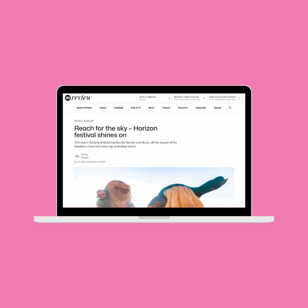 Laptop screen displaying an online article on InReview Queensland. Pink background.
