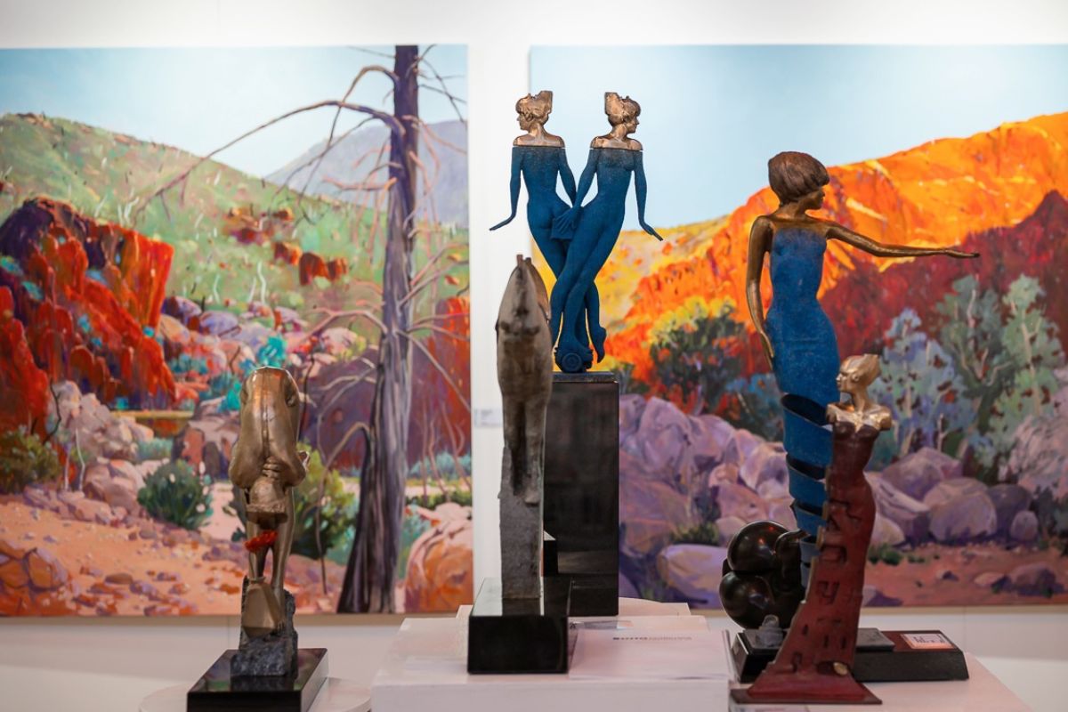 Art exhibiting at Affordable Art Fair Melbourne. Sunset-style painting with sculptures of people in-front.