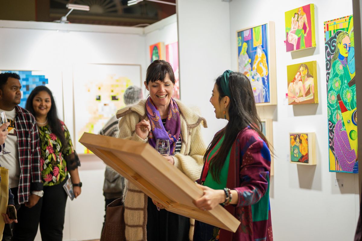 Two guests at Affordable Art Fair Melbourne looking at a Canvas