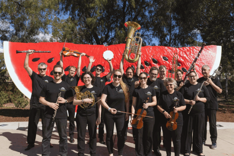 Image of orchestra players in front of the big watermelon