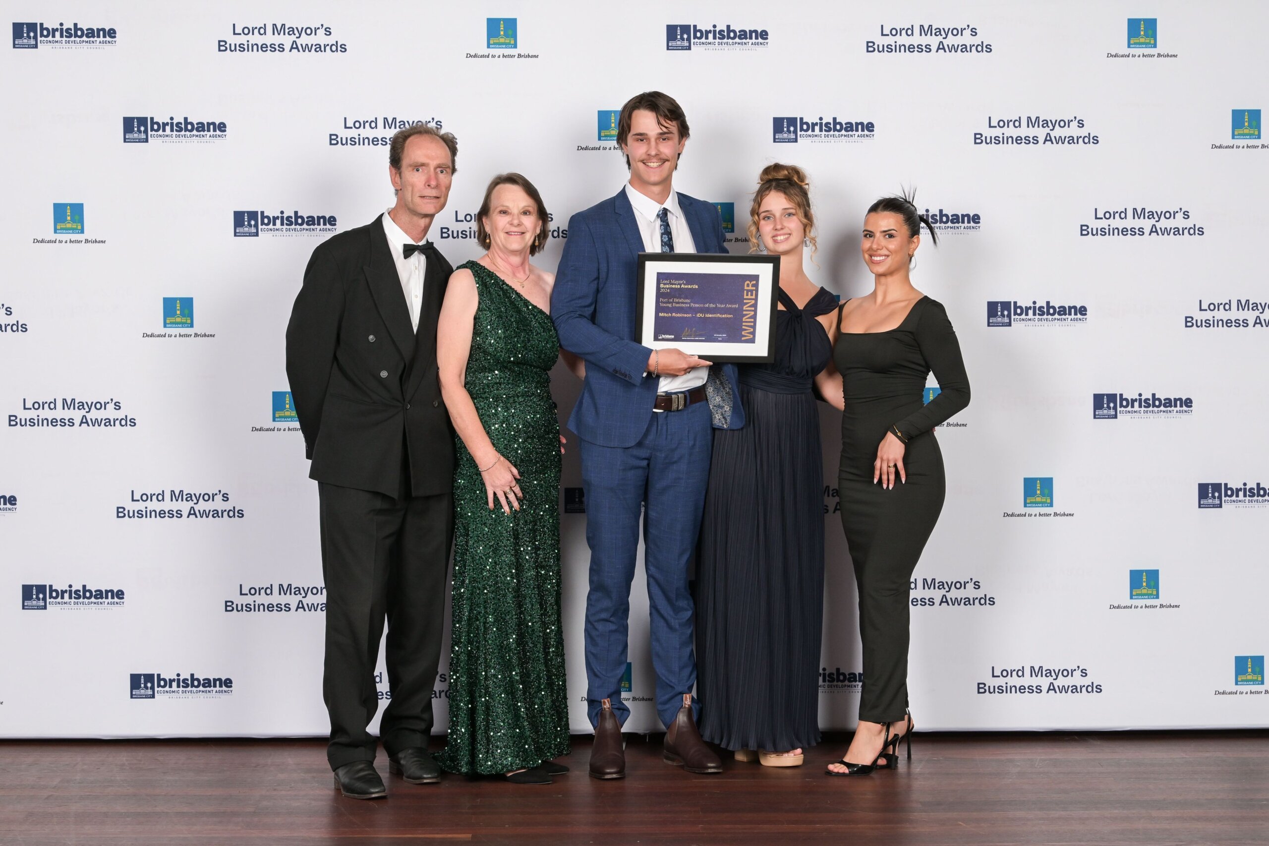 LMBA 2024 Young Business Person of the Year Mitch Robinson 2024 Young Business Person of the Year Mitch Robinson pictured alongside his family in business attire while holding a placard recognising the win.