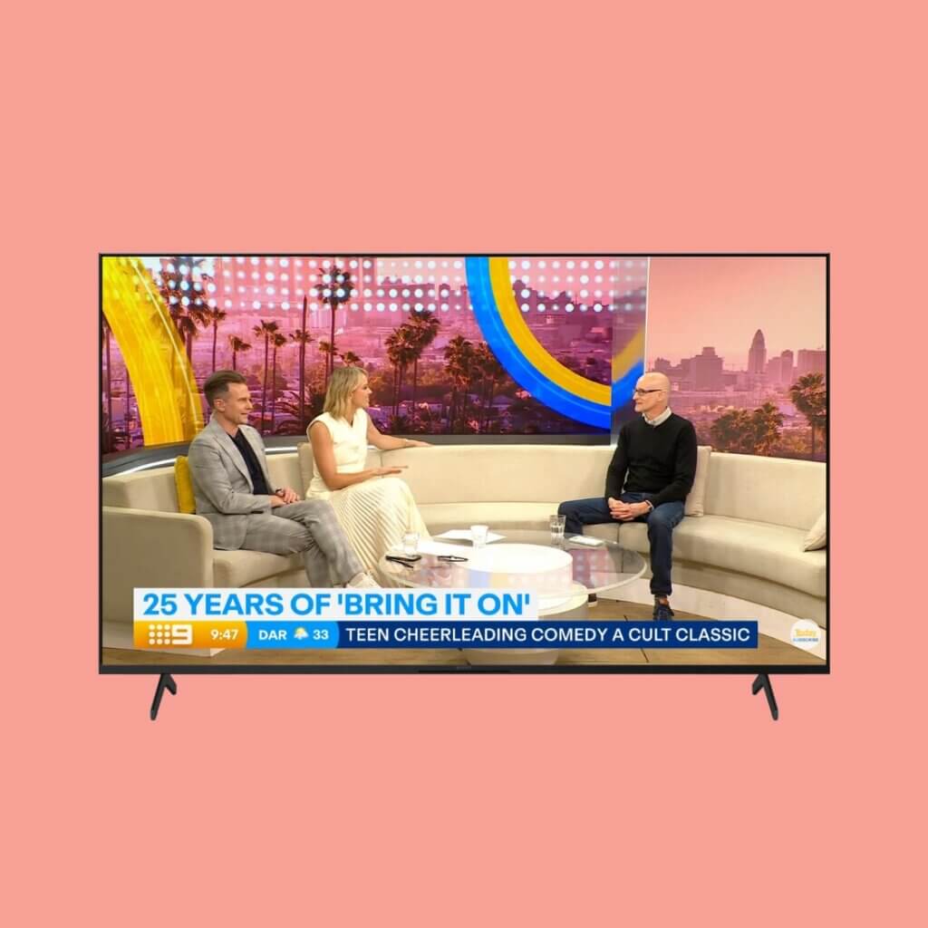 A salmon-coloured background with TV screen within. Today Extra featuring a couch with three people seated for Brisbane International Film Festival. Text reads '20 years of Bring It On.'